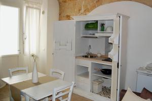 莫诺波利Locazione turistica Casa Gemma的厨房配有桌子和白色冰箱。