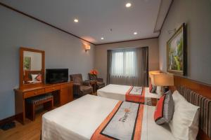 河内Hanoi Larosa Hotel的酒店客房设有两张床和电视。