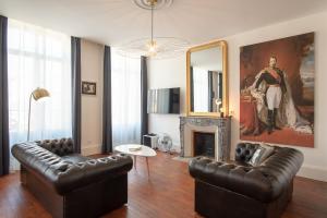 沙勒维尔-梅济耶尔suite Napoléon III的客厅配有2张真皮沙发和壁炉