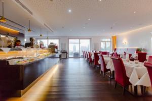 巴登-巴登水西城安东特尔蒙酒店的一间设有红色椅子和自助餐的餐厅