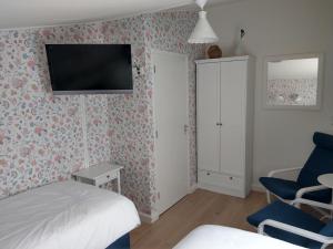 诺德施华伍德B&B De Blauwe Tulp的卧室配有一张床,墙上配有电视。