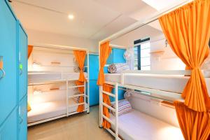孟买goSTOPS Mumbai的配有白色双层床和橙色窗帘的房间
