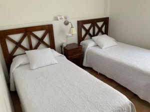 圣何塞Santuario San José的一间卧室设有两张床,墙上配有一盏灯。