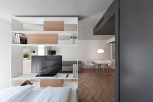 慕尼黑慕尼黑帕克斯塔德施瓦宾商务雅致公寓式酒店的一间卧室配有一张床和一张书桌及电视