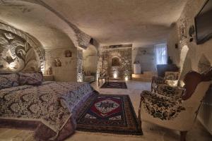 格雷梅Kayatas Cave Suites的一间卧室,卧室内配有一张床和椅子