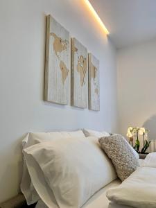 阿科Appartamenti Villa Sonia的白色卧室,墙上有4张地图