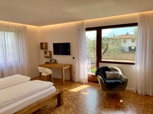 阿科Appartamenti Villa Sonia的卧室配有床、椅子和窗户。