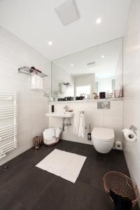 洪堡Schlossberg Hotel Homburg的白色的浴室设有卫生间和水槽。