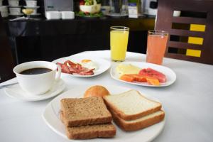 拉巴斯Delfines Apart Hotel的餐桌,包括两盘早餐食品和一杯咖啡