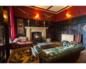 柯比斯蒂芬奥吉尔城堡民宿的客厅配有皮革家具和壁炉