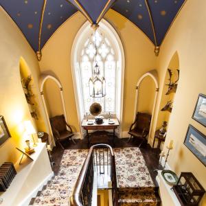 柯比斯蒂芬奥吉尔城堡民宿的阁楼走廊设有大窗户和螺旋楼梯