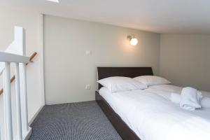 赞德沃特New Point的一间卧室配有带白色床单和枕头的床。