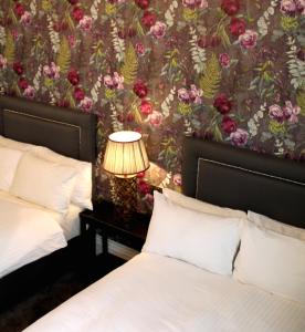 布伦特福德金斯阿姆斯酒店的一间卧室设有两张床和鲜花墙
