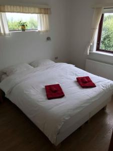 海拉Selalækur Country Guesthouse的一张白色的床,上面有两条红色的毛巾