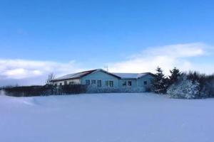 海拉Selalækur Country Guesthouse的前面的雪覆盖着房子