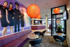 美因河畔法兰克福法兰克福机场梅宁阁酒店的大堂设有紫色的沙发和桌椅