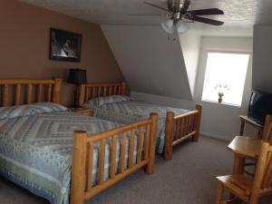 特罗皮克Bullberry inn Bed & Breakfast的一间卧室配有两张床和吊扇