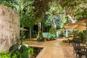 巴利亚多利德Verde Morada的一个带桌子和遮阳伞的庭院和一个游泳池