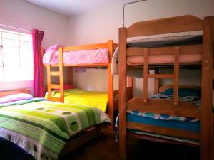 库斯科Tinki Hostel的一间卧室配有两张双层床和一张床
