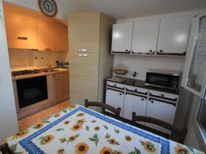 Mortola SuperioreApartment Taverna Il Cippo by Interhome的厨房配有桌子和向日葵毯子