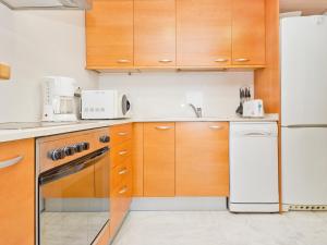 安波拉Apartment Edificio Nautic by Interhome的厨房配有木制橱柜和白色冰箱。