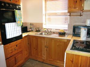 ValleyHoliday Home Glenvale Cottage by Interhome的一个带木制橱柜和水槽的厨房