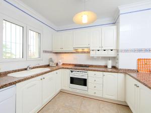 德尼亚Holiday Home Tossal Gros by Interhome的白色的厨房配有白色橱柜和水槽