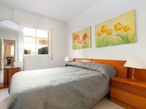 德尼亚Apartment Cascadas de la Marina-4 by Interhome的卧室配有一张床,墙上挂有两幅画