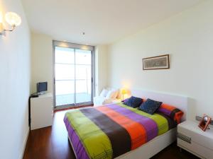 巴塞罗那巴塞罗那加西亚法利亚大道公寓的窗户房间里一张色彩缤纷的床