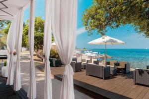 乌马格Hotel Coral Plava Laguna的一个带白色遮阳伞和椅子的庭院,享有海景。