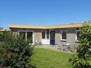 诺德克豪特Holiday Home De Wijde Blick by Interhome的砖砌建筑,设有庭院和桌椅