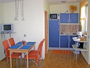 滨湖克拉科Holiday Home Goetheallee by Interhome的厨房配有蓝色橱柜和桌椅