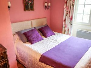 科利Holiday Home La Colinoise by Interhome的粉红色的卧室配有一张带紫色枕头的床