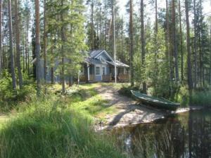 LahdenkyläHoliday Home Käpälämäki by Interhome的树林中的一个小房子,水中有一船