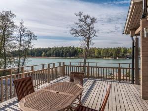 HoutskariHoliday Home Kärki by Interhome的木甲板配有桌椅和湖泊