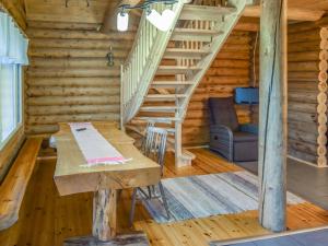 HerttualaHoliday Home Leporanta by Interhome的小木屋内带桌子和楼梯的用餐室