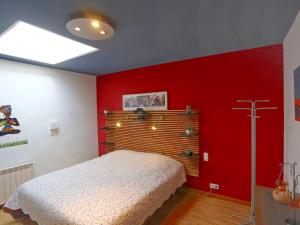 坎布里尔斯Holiday Home Torre del Sol by Interhome的卧室设有红色墙壁,配有一张床