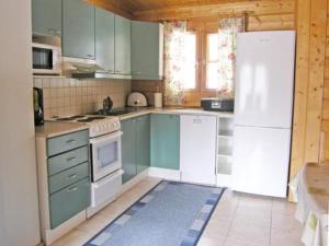 拉赫登佩拉Holiday Home Rusakko by Interhome的厨房配有绿色橱柜和白色冰箱