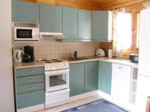 拉赫登佩拉Holiday Home Rusakko by Interhome的厨房配有蓝色橱柜和白色家电