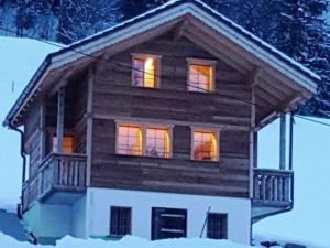 阿德尔博登Apartment Chalet Wäschhüsi by Interhome的小木屋,其灯光照在雪上