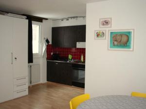 英格堡Apartment Sörenweg 5 by Interhome的一间带桌子的厨房和一间带红色瓷砖的厨房