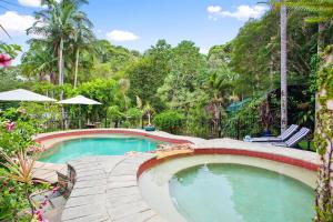 Doonan努沙谷庄园住宿加早餐酒店的度假村的游泳池,带椅子和树木