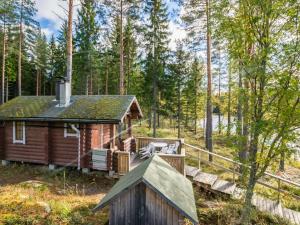 MajavesiHoliday Home Kannonniemi by Interhome的树林中的小屋,设有门廊和甲板