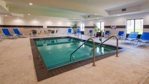 阿德莫尔阿德莫尔贝斯特韦斯特PLUS酒店的一个带蓝色桌椅的大型游泳池