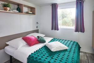 比涅维勒珀特德斯沃哥斯露营地的一张床上有色彩缤纷的枕头