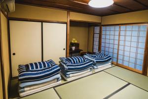 松江市KIAN the guest house的一间设有4个蓝白条纹枕头的客房