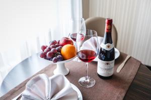 EkibastuzHotel Home Parq的一张桌子,上面放着一瓶葡萄酒和一碗水果