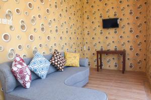 日惹RedDoorz near Terminal A Adisucipto Airport的客厅配有带枕头的蓝色沙发