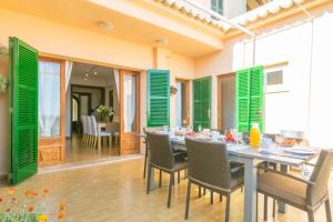 塞尔瓦Ca Sa Tia Vicari的一间设有绿色百叶窗和桌椅的用餐室
