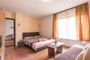 萨拉热窝凯泽旅馆的一间卧室设有一张床和一间客厅。